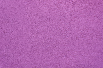 Background of painted rough stucco purple wall.