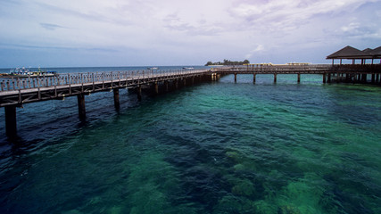 Fototapeta na wymiar Wooden Beach Dock or Wooden Pier at Tropical Beach