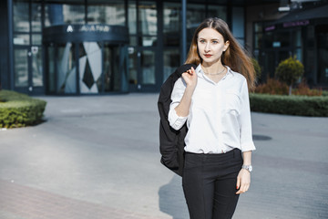 A business woman goes down the street. A girl in a business suit at the office. A wonderful girl in the city.