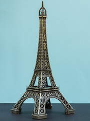 Toy eiffel tower on the blue pastel background.Symbol of France.