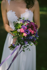 wedding bouquet with violet roses and long ribbon
