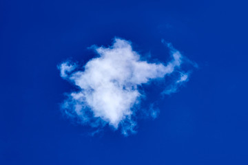 lonely white fluffy cloud on blue sky background