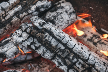 Hot coals from wood in a campfire. Natural firewood background.