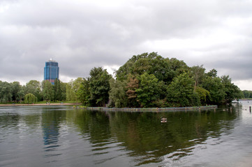 Fototapeta na wymiar Lake with an island and a skyscraper in Hyde Park - London, United Kingdom