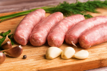 Sausages for grilling, dill and garlic on a wooden cutting board