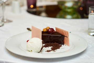 Black forest slice cake with cherry, vanilla ice-cream, chocolate dirt on a white plate, close-up. Tradidional delicious sweet dessert food 