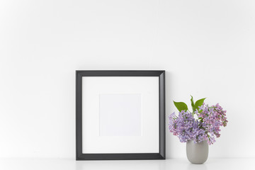 Black square frame with lilac bouquet on white background