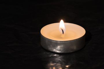 Burning candle on a black background. Selective focus