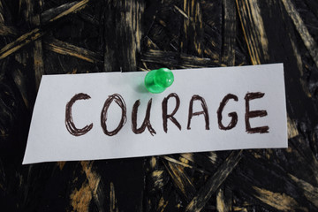 written courage on a white sheet of paper