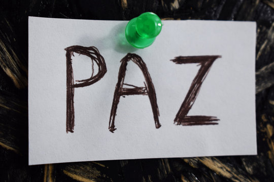 paz  written in Spanish, means to peace, on a white sheet of paper