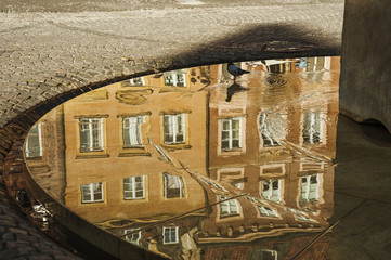 Building reflection/Shallow water surface on a street fountain reflecting a building in the old town main square of Warsaw.