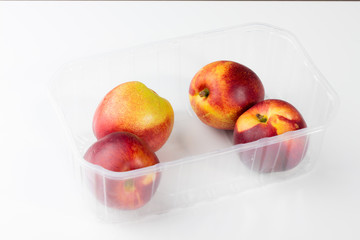 Pfirsiche in Plastikschale zum Transport und Aufbewahrung