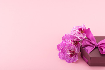 Pink spotted orchid flowers with gift box. Сelebratory background