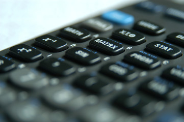 Calculator on a desk next to a window in a library at university. Studying math and doing homework at school. Studying for math or statistics exam at university. Business and finance concept.