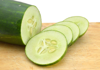 Sliced Cucumber in Stack on wooden board isolated on white