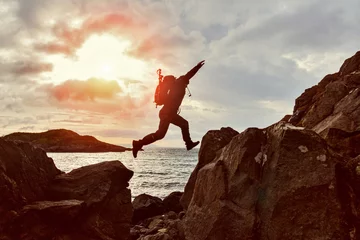 Fotobehang Jumping man hiker over a gap between two rocks © -Marcus-