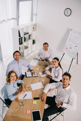 high angle view of smiling business colleagues at workplace in office
