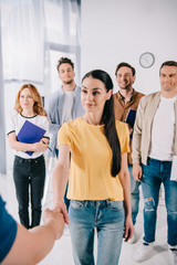Fototapeta premium partial view of businesswoman shaking hands with mentor after business training in office