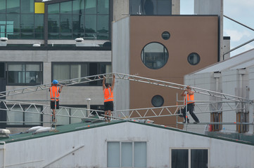 Builders assembling a metal frame on a building roof