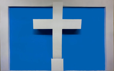 cruz blanca que sobresale de la pared, con un fondo azul