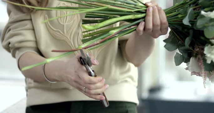 Young Florist Cuts the Stems of Flowers in the Bouquet