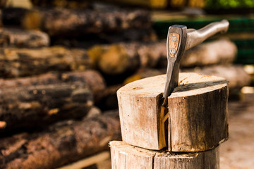closeup view of sticking axe in log at sawmill