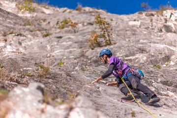 Young man lead climbing on cliff