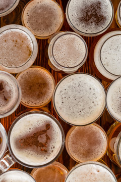 A variety of full, frothy beer glasses and sizes