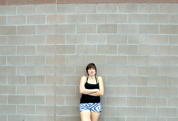 Sexy female beauty expressions against a wall outside.