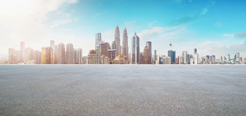 Empty asphalt road with modern city skyline .