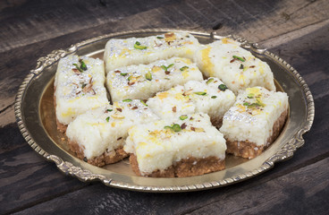 Indian Diwali Sweet Food Kalakand Also Know as Halwa or Mawa Kalakand is a Creamy Delicacy Made From Paneer or Cottage Cheese, The Dish Originated in Alwar, Rajasthan. Kalakand on Wooden Background