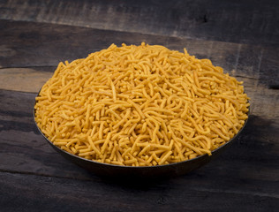 Indian Namkeen Food Spicy Yellow Sev on Vintage Wooden Background