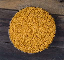 Indian Namkeen Food Spicy Yellow Sev on Vintage Wooden Background