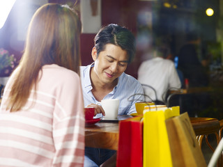 young asian couple chatting in coffee shop