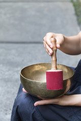 Big Tibetan singing bowl in the hands of a woman