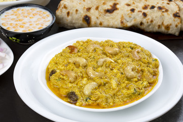 Indian Traditional Vegetarian Cuisine Kaju Curry Also Called Kaju Butter Masala Served with Tandoori Roti, Raita, Salad And Papad