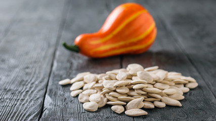 A bunch of pumpkin seeds and a small fruit on the village table.