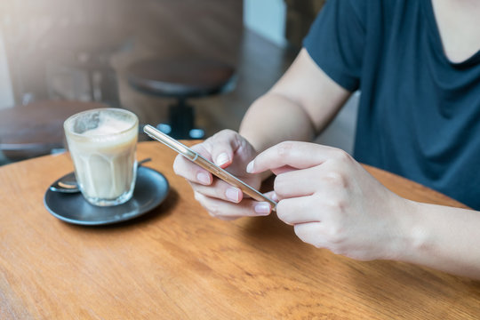 woman hand using smartphone for mobile transaction or shopping online in coffee shop. (fintech, financial and technology concept)
