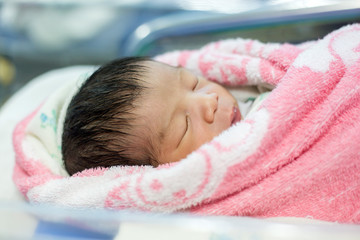 new born infant asleep in the blanket in delivery room