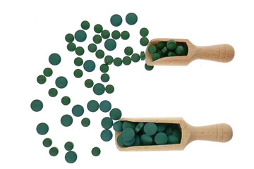  spirulina.Algae spirulina tablets in a wooden scoop isolated on a white background. green alga spirulina.Super food concept. seaweed in tablets. Food supplements for a healthy lifestyle