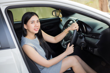 Obraz na płótnie Canvas Pretty Asian women in a white car happy driving