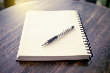 notebook and pen on a wooden table