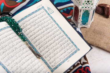 Quran - holy book of Muslims with lanterns with with rosary beads and dates. Ramadan concept