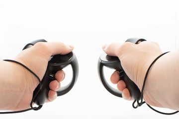 Virtual Reality Controllers Being Held By Adult Male Hands On White Background. © Brian