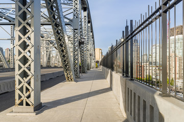 footpath on a bridge with metal supports in a modern city