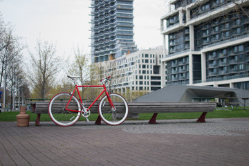 Fototapeta premium red bicycle parked by a bench 