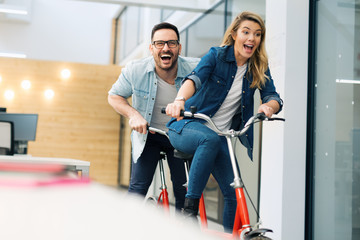 Business people having fun riding a bicycle