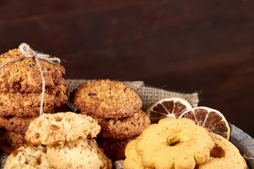 Conceptual composition with assortment of cookies and cinnamon on a wooden barrel, selective focus, close-up