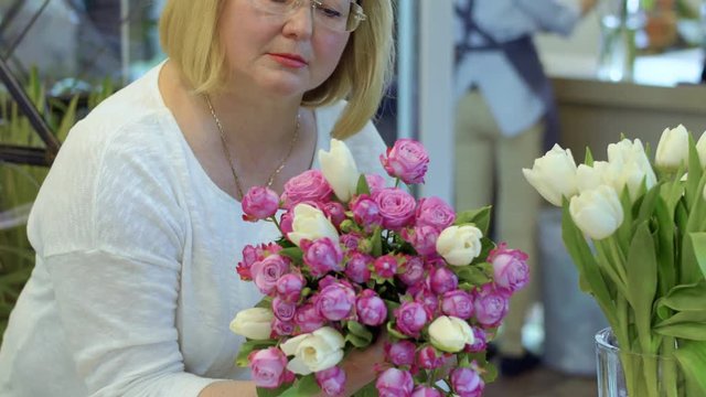 Mature woman hold bouquet of roses and tulips