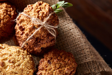 Conceptual composition with assortment of cookies on burlap napkin on a wooden barrel, selective focus, close-up